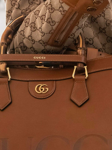 Gucci Large GG Logo Beige Canvas Brown Leather Strap Duffle Bag – Queen Bee  of Beverly Hills
